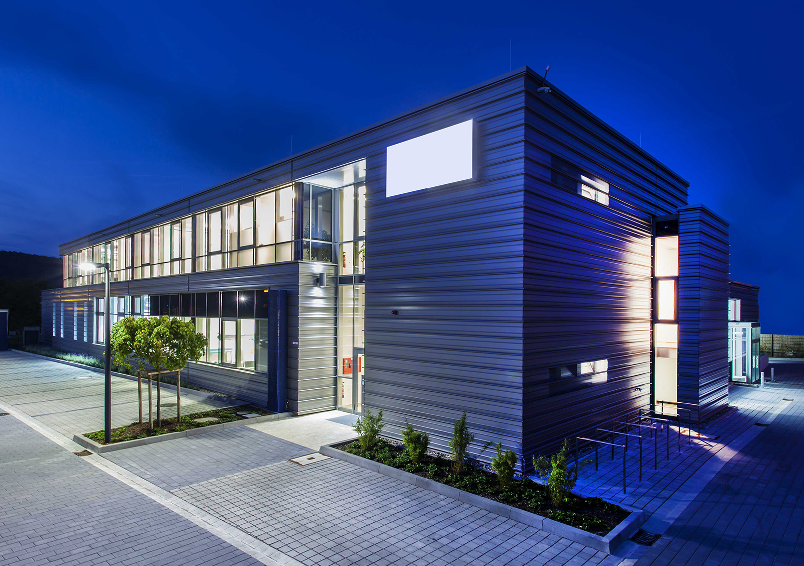 Kasettenwandkonstruktion mit hinterlüfteter Fassade bei Nacht